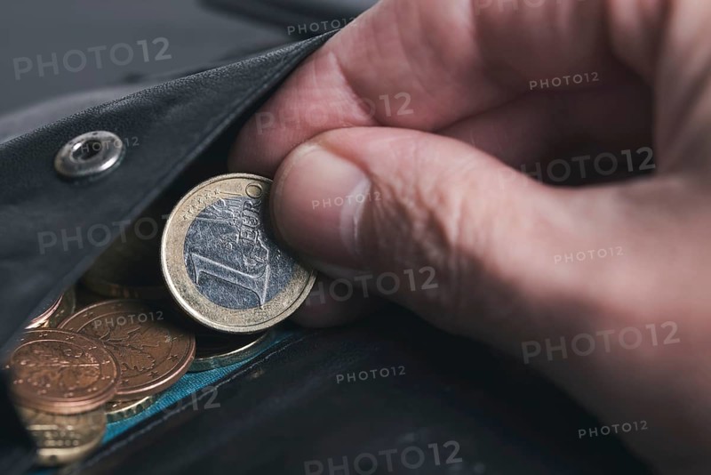 close-up of person picking 1 Euro coin from wallet, spending money business concept
