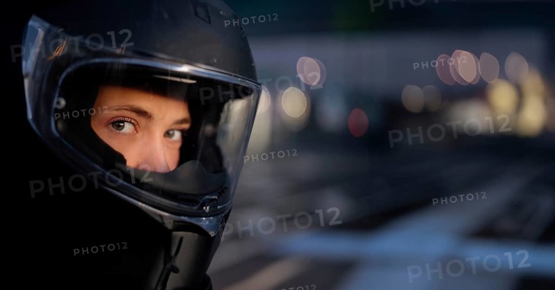 Young beautiful woman motorcyclist in a motorcycle helmet, road safety, motorcycle equipment