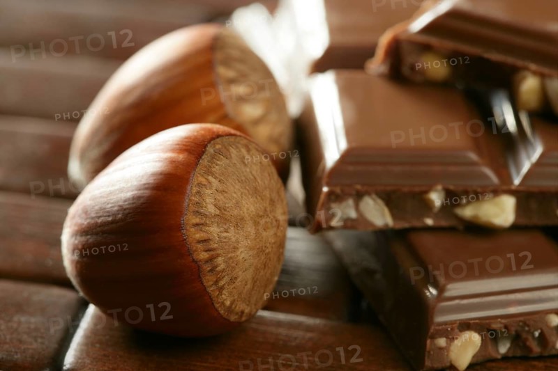 Hazelnuts and chocolate on brown wood enviroment at studio