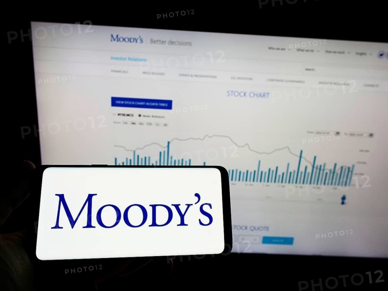 Stuttgart, Germany, 10-09-2022: Person holding mobile phnoe with logo of rating company Moody's Investors Service Inc. on screen in front of web page. Focus on phone display, Europe