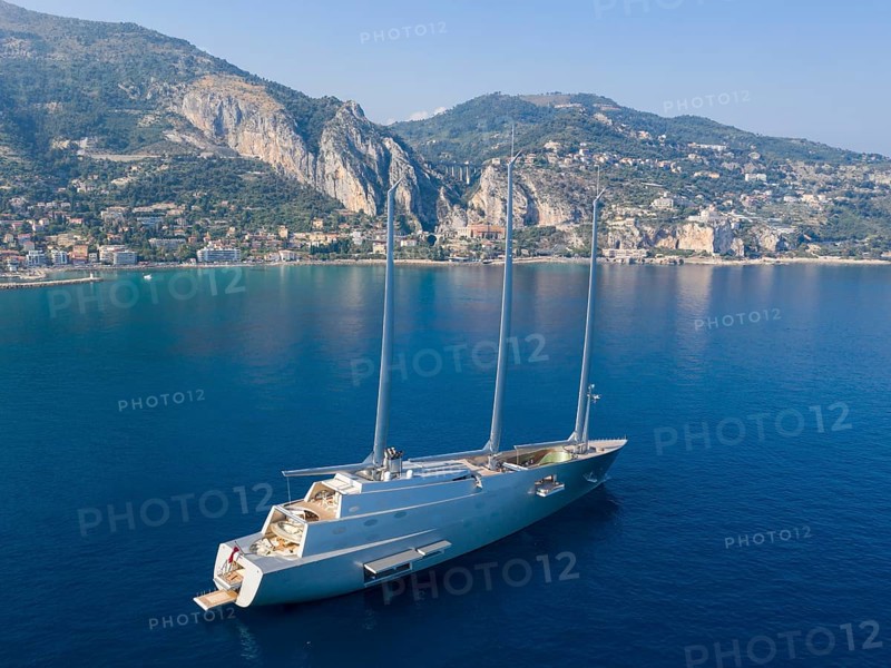 Aerial view 143 metre long three-master Sailing Yacht A, the largest sailing yacht in the world, built to a design by designer Philippe Starck by the German shipyard Nobiskrug and delivered in 2017 to the Russian oligarch Andrei Melnichenko, Andrey Melnichenko, over 100 metre high carbon masts, at anchor off Menton, Cote d'Azur, Mediterranean Sea