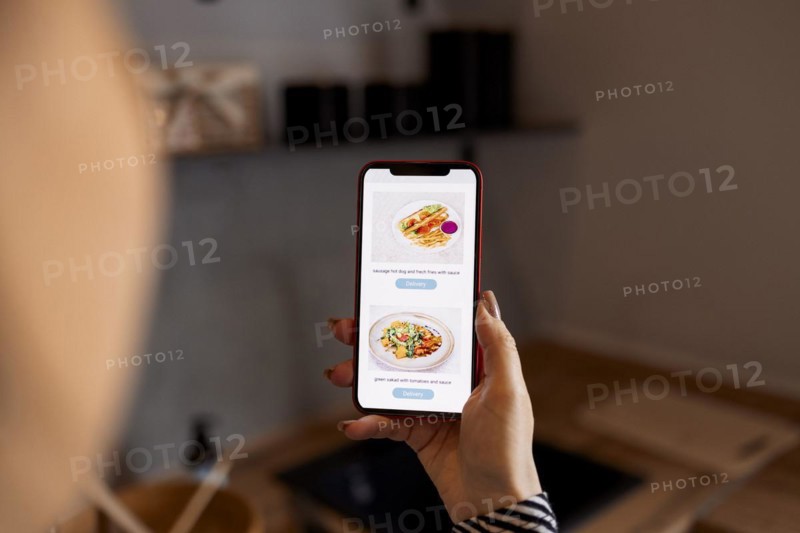 Happy shopper ordering from internet shop, using app on mobile phone for giving positive review to store. Woman using smartphone, ordering delivery service