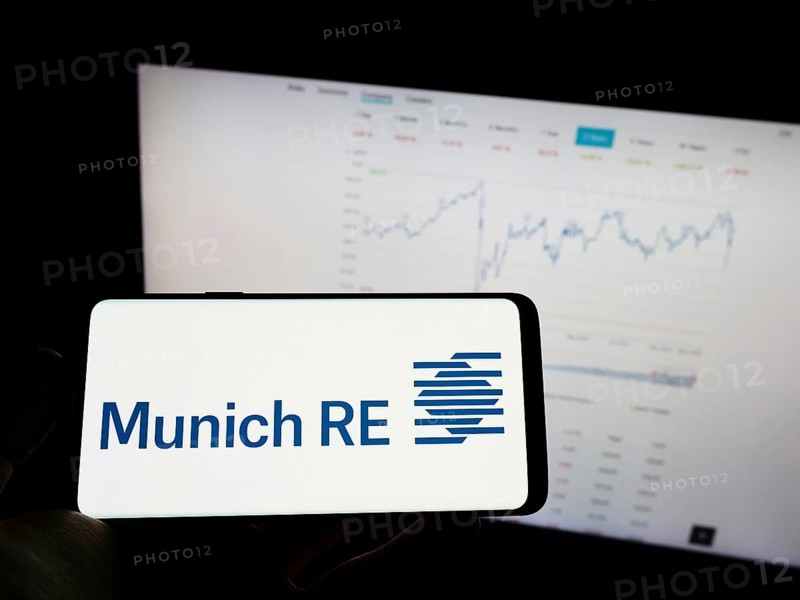 Stuttgart, Germany, 03-06-2022: Person holding cellphone with logo of German insurance company Munich Re Group on screen in front of business webpage. Focus on phone display, Europe