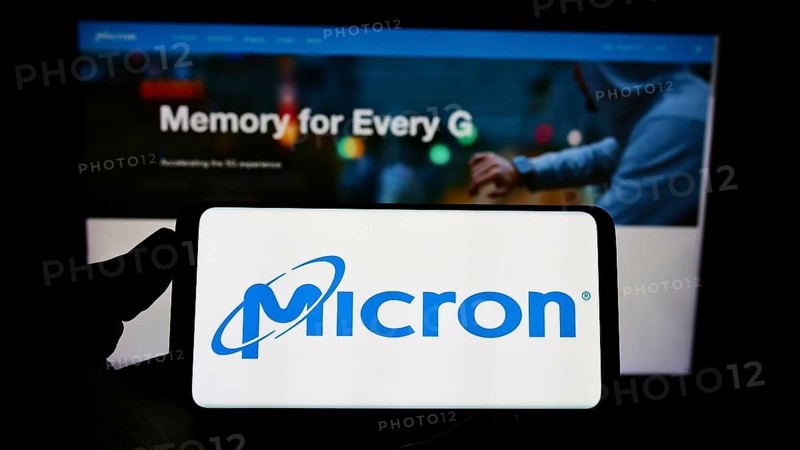 Stuttgart, Germany, 12-01-2022: Person holding cellphone with logo of American semiconductor company Micron Technology Inc. on screen in front of webpage. Focus on phone display, Europe