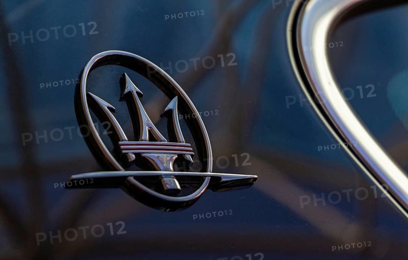 A close-up picture of the Maserati logo on the back of a vehicle