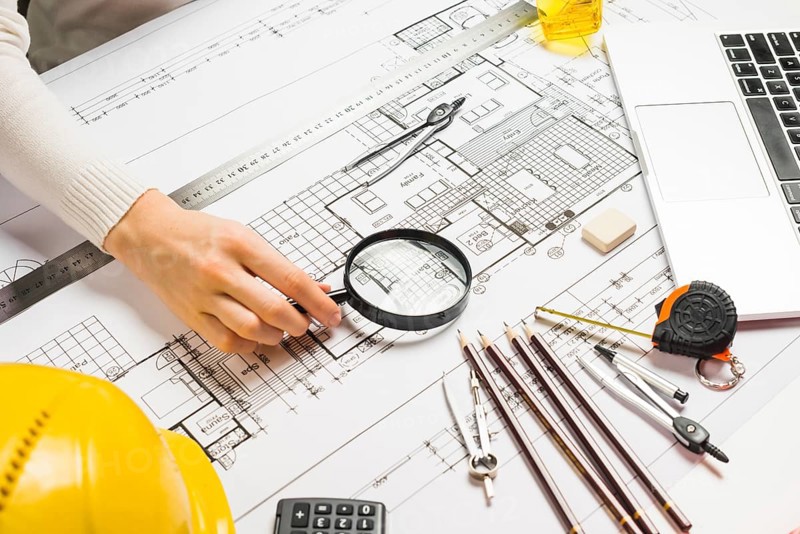 Person using magnifyer blueprint