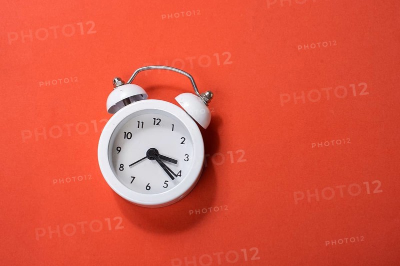 Alarm clock on colorful background in view