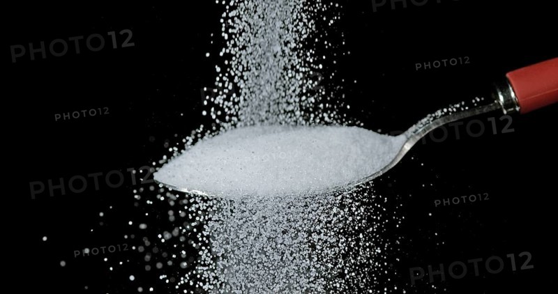 White Sugar falling against Black Background