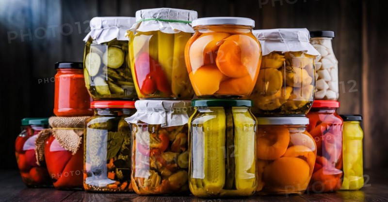 Jars with variety of marinated vegetables and fruits. Preserved food
