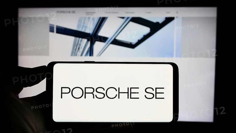 Stuttgart, Germany, 08-20-2023: Person holding cellphone with logo of German company Porsche Automobil Holding SE on screen in front of business webpage. Focus on phone display, Europe