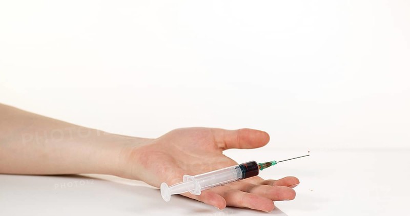 Medical Product Falling into Hand against White Background