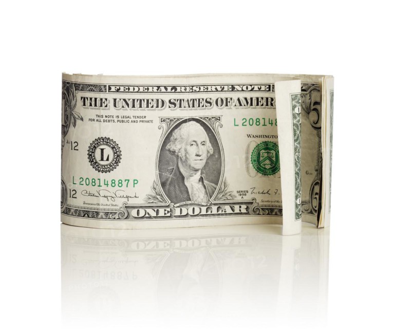Old curly US dollar bills isolated on white with natural reflection