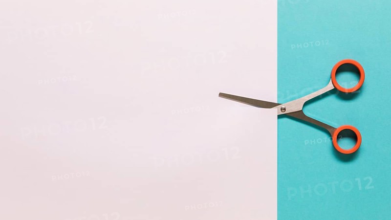 Scissors cutting white paper. High resolution photo