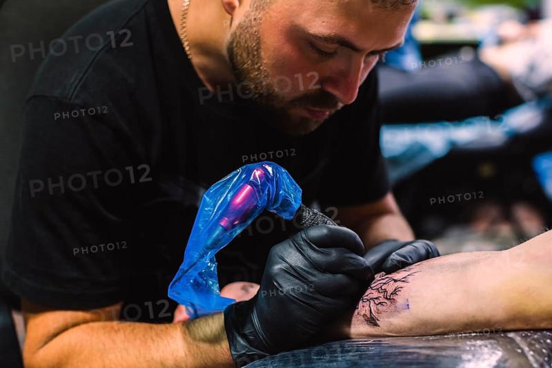 Master doing tattoo with iron salon