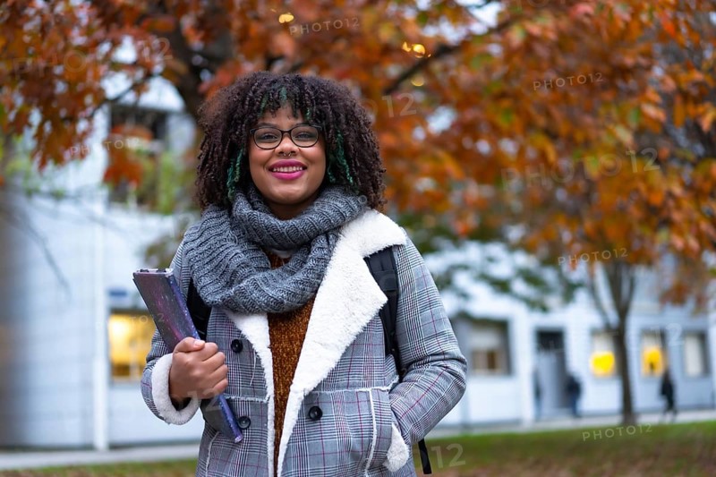 Portrait of black ethnic girl strolling in college college in fall back to school