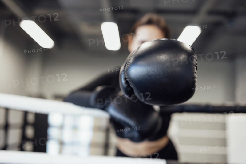 Strong latin boxing woman on the ring at fitness gym. Athletic girl training Muay Thai boxing for bodybuilding and healthy lifestyle concept. Workout in sport club