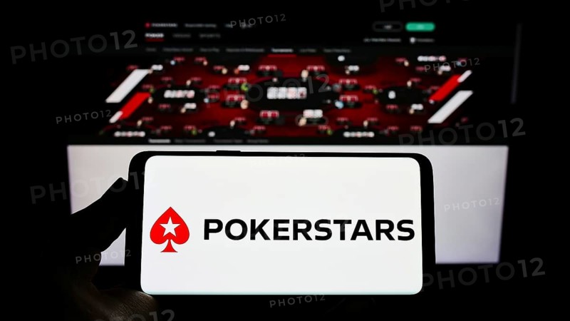 Stuttgart, Germany, 01-06-2022: Person holding smartphone with logo of online poker cardroom PokerStars on screen in front of website. Focus on phone display, Europe