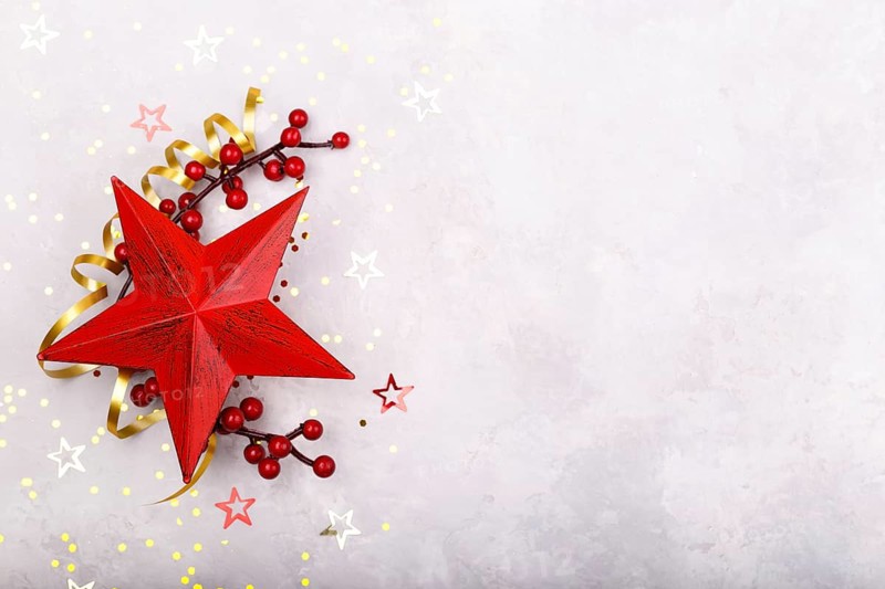 Red star berries Christmas decorations on grey stone background flat lay copy space