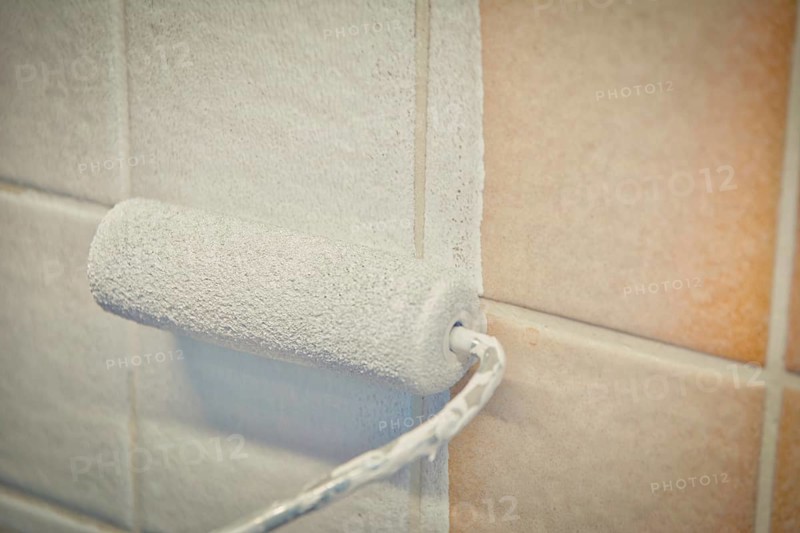Painting old tiles in the kitchen or bathroom white with a small roller and two component paint. Interior renovation