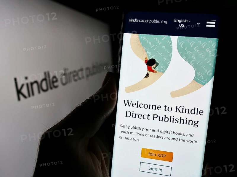 Stuttgart, Germany, 11-09-2023: Person holding mobile phone with website of Amazon e-book platform Kindle Direct Publishing (KDP) with logo. Focus on center of phone display, Europe
