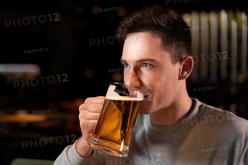 Close up man drinking beer from mug