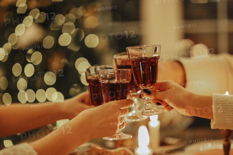 Family friends have fun together in winter eating food on a wooden table. Concept of friendship. Joyful people enjoying celebration at home or restaurant. Holiday concept