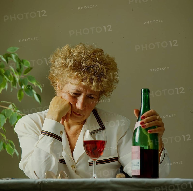 Older woman with wine glass and bottle