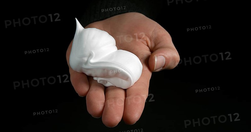 Hand of Woman and shaving foam against Black Background
