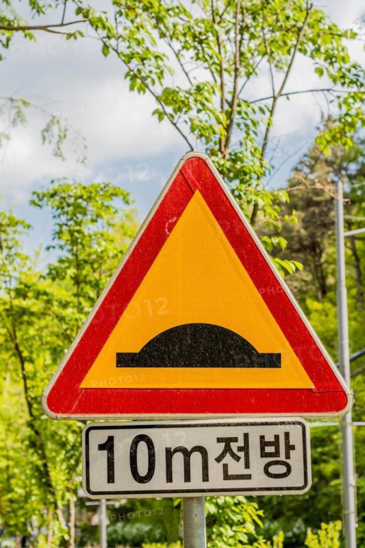 A traffic sign warning of a speed bump ahead with Korean text beneath, in Daejeon, South Korea, Asia