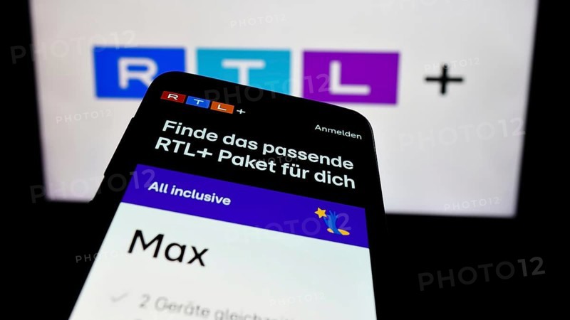 Stuttgart, Germany, 02-13-2024: Mobile phone with website of German entertainment platform RTL plus in front of business logo. Focus on top-left of phone display, Europe