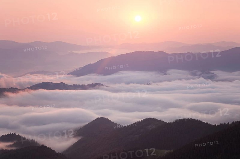 Sunrise over cloudy mountain ridge