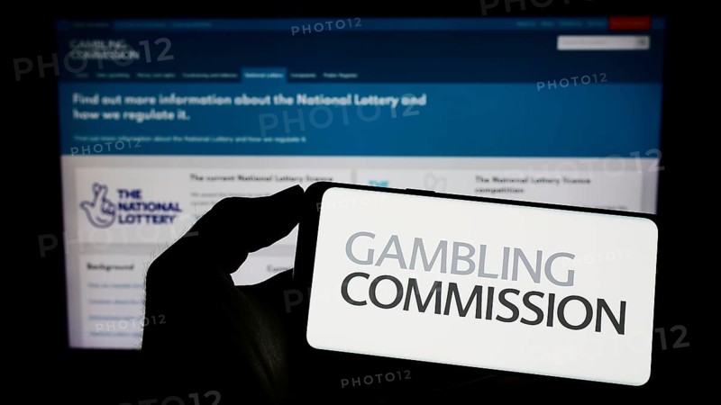 Stuttgart, Germany, 04-01-2023: Person holding cellphone with logo of British public body Gambling Commission on screen in front of webpage. Focus on phone display, Europe