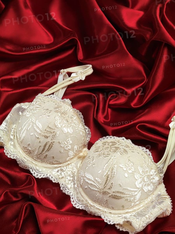 White lacy bra on red shiny silky fabric