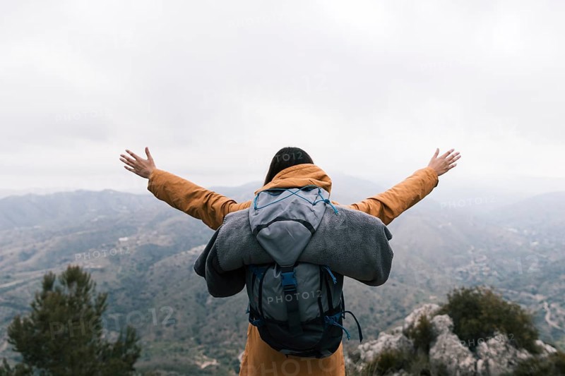 Female backpacker standing top mountain loving nature