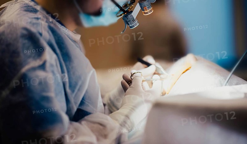 Work of a surgeon in the operating room, a surgical instrument in hand