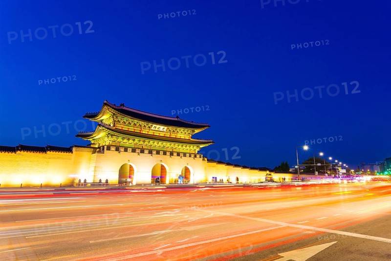 Long exposure streaking car tail lights leaving trailing light in front of Gwanghwamun main gate to Gyeongbokgung Palace at dusk in downtown on a clear night in Seoul, South Korea, Asia