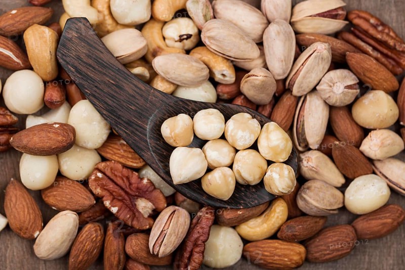 Various organic nuts snack spoon background