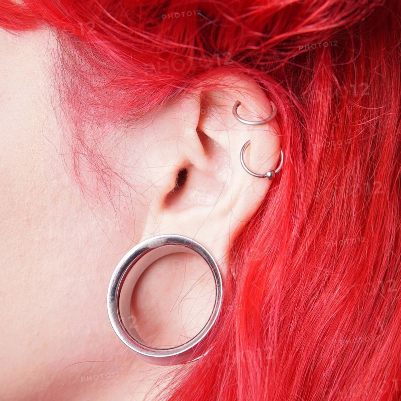 Stretched earlobe piercing with flesh tunnel