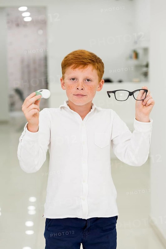 Boy holding plastic container contact lenses eyeglasses looking camera