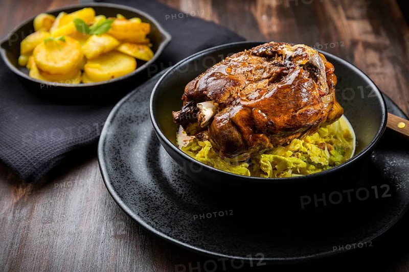 Roaster Pork Knuckle with savoy cabbage and baked potatoes - Traditional German cuisine, Eisbein, Schweinehaxe