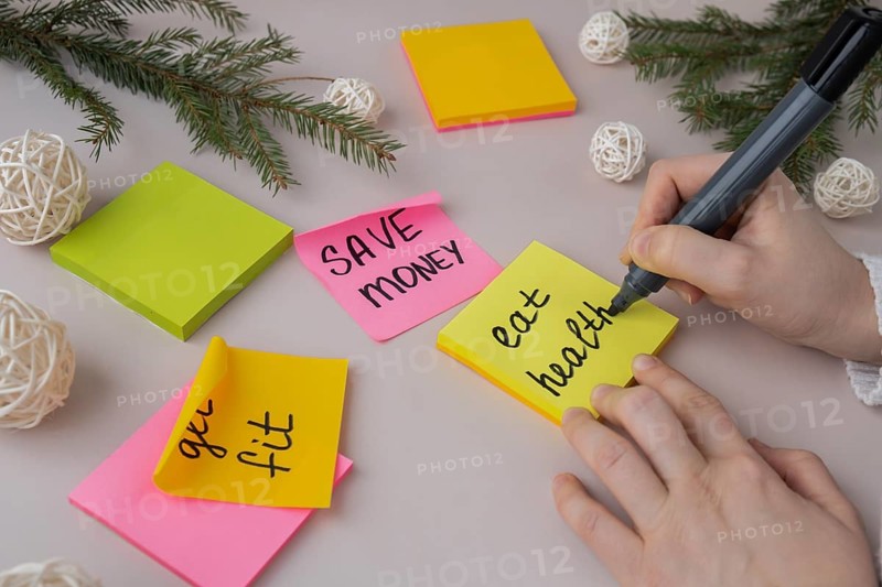 Woman writing promises and aims. Preparation for new year new life new me. Visualizing wish list for 2025. Dreams plan action resolutions for coming year. Inspirational self improvement concept