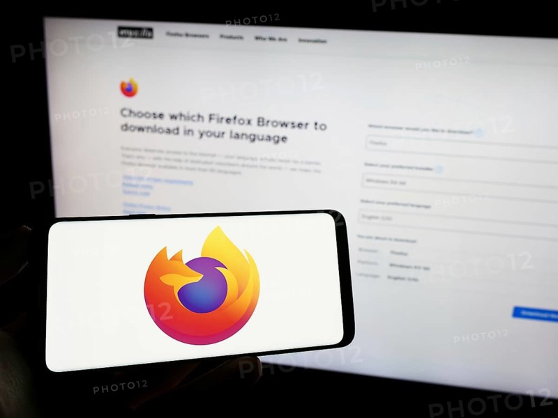 Stuttgart, Germany, 09-22-2023: Person holding cellphone with logo of open-source web browser Mozilla Firefox on screen in front of webpage. Focus on phone display, Europe
