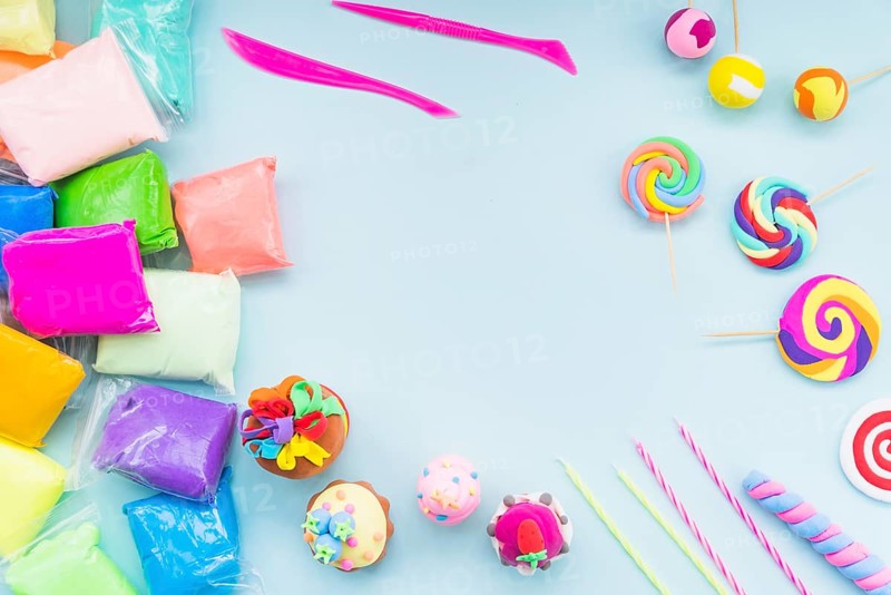 Colorful clay plastic bag with fake cake lollipop blue background