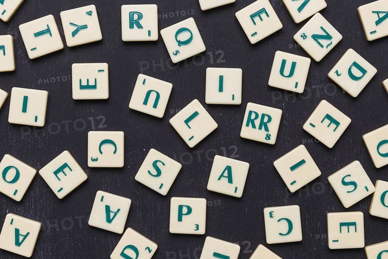 Close up scrabble letters against black background. High resolution photo