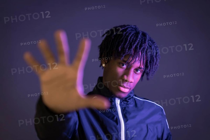 Black person doing the stop racism gesture on a black background