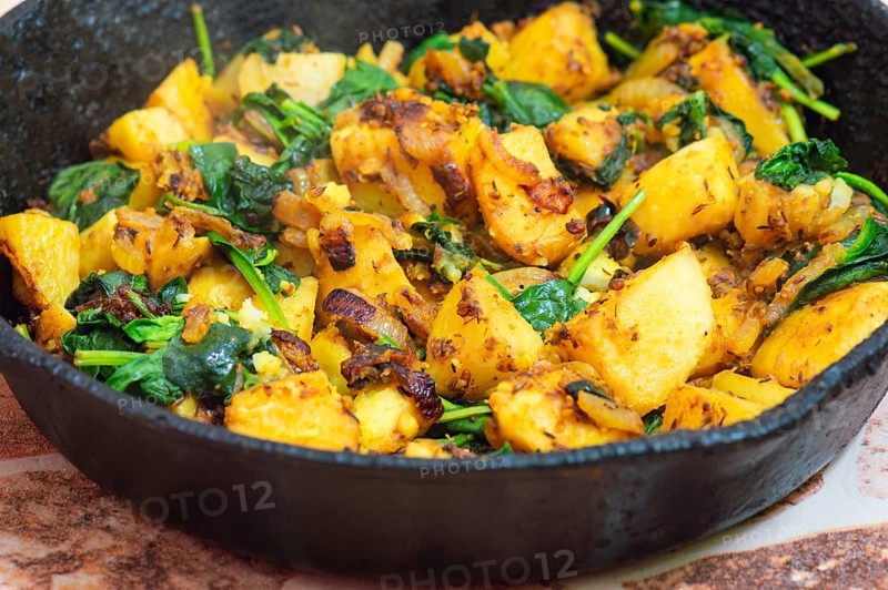 Saag Aloo, Indian style spinach and potato dish in cast iron pan
