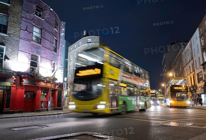 A Dublin bus speeds past Doyle's pub and on towards Trinity College at night time. Dublin, Ireland, Europe
