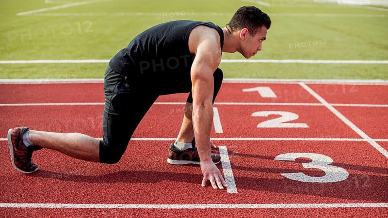 Side view male runner sprinter getting ready start race. High resolution photo