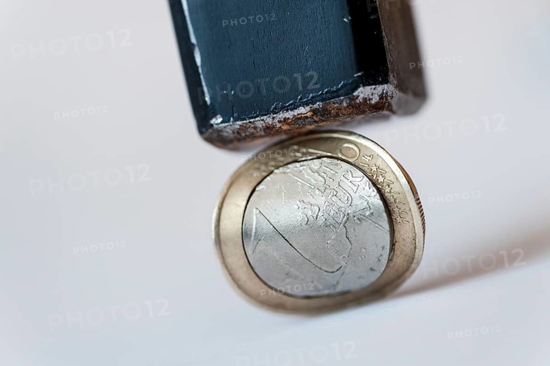 Euro coin with converx curvature under a hammer