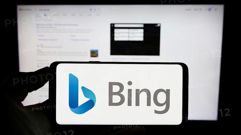 Stuttgart, Germany, 09-22-2023: Person holding cellphone with logo of web search engine Microsoft Bing on screen in front of business webpage. Focus on phone display, Europe